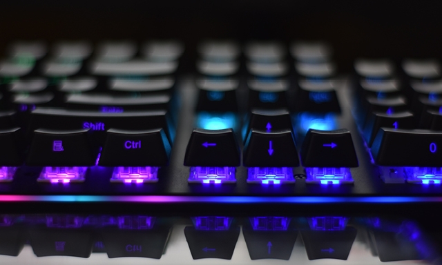 A computer keyboard illuminated in rainbow colours