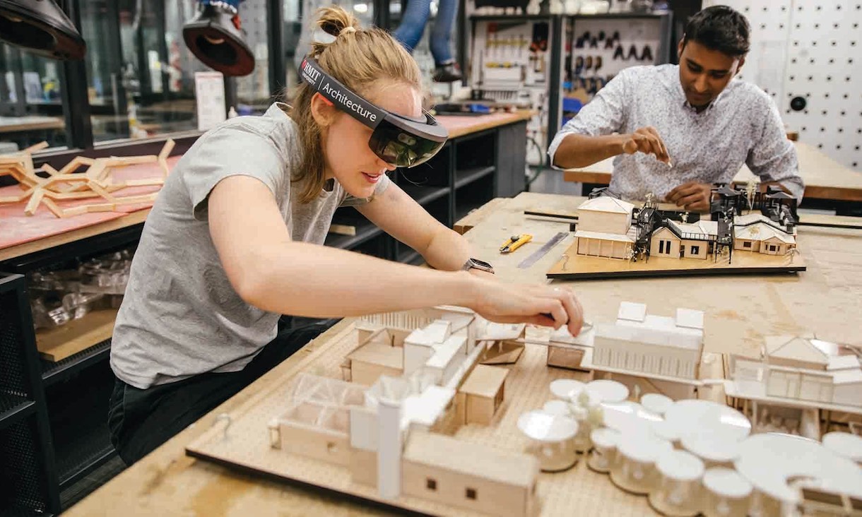 Students create wooden models in a workshop.