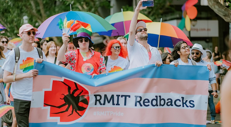 Students carrying the Redbacks (RMIT sports community) Trans Pride banner.
